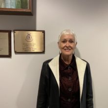 woman smiling in front of plaques