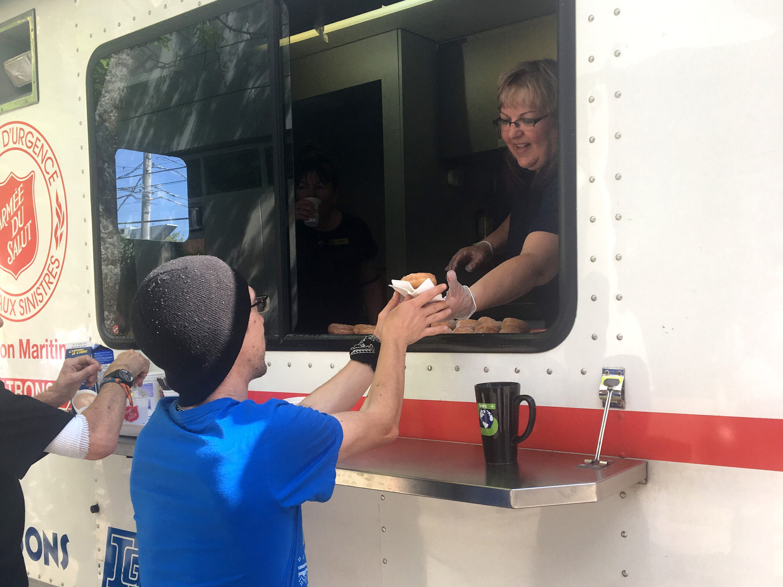 A worker on the Community Resource Unit serves donuts to clients at the Centre of Hope in Halifax