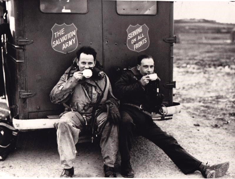 two men sit drinking coffee