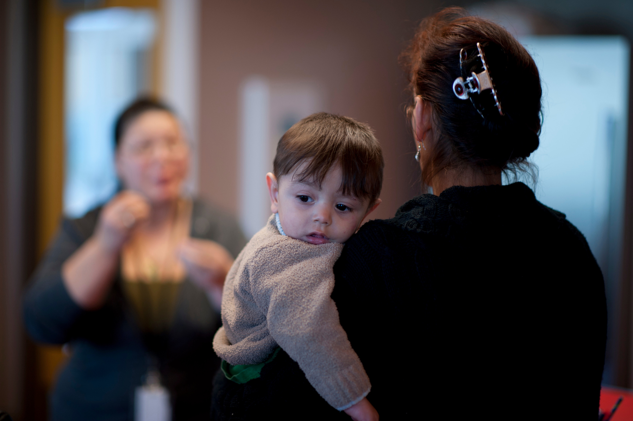 child and his mother talking to another woman