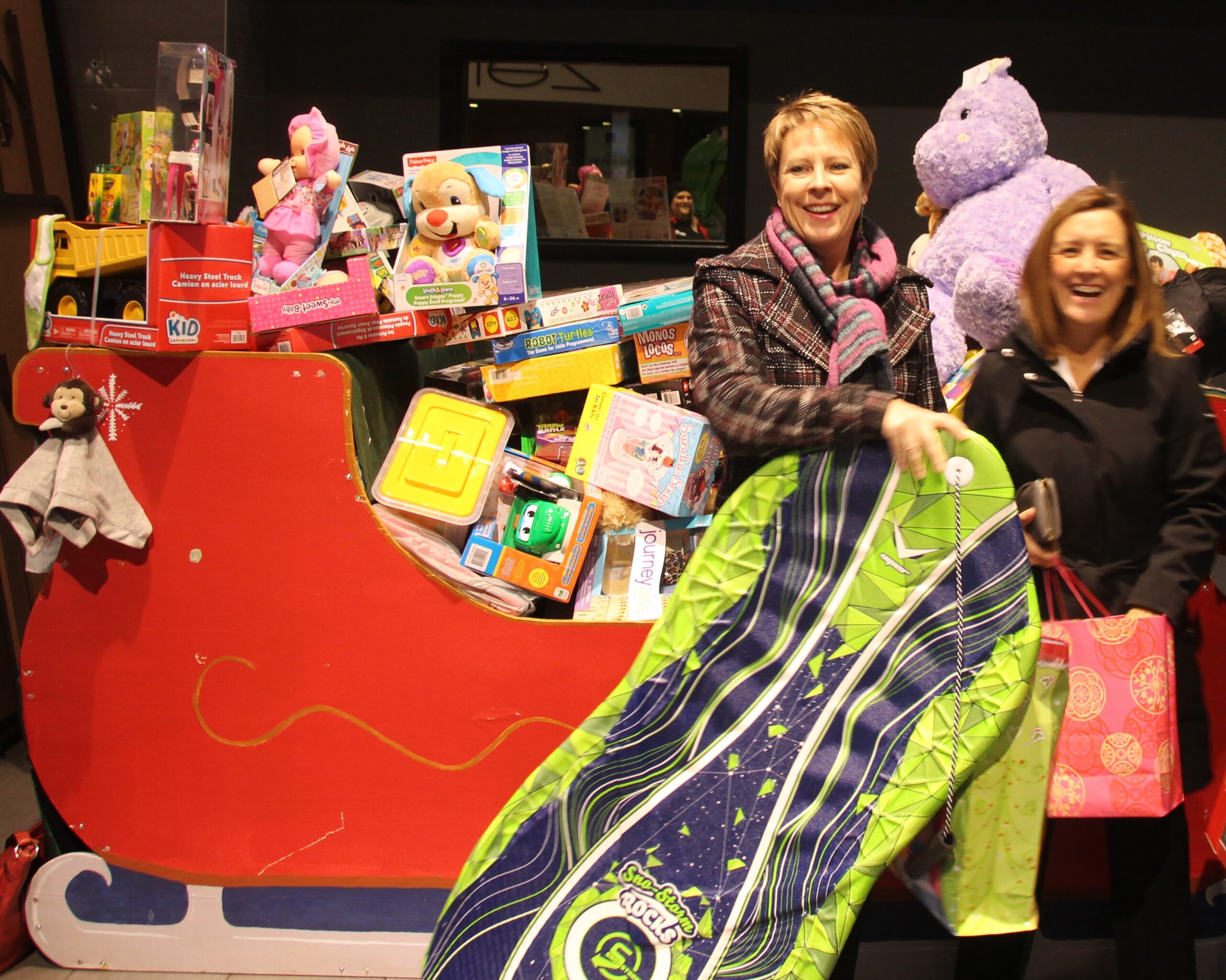 Two women pose for a photo at the Cineplex-C100 Toy Drive