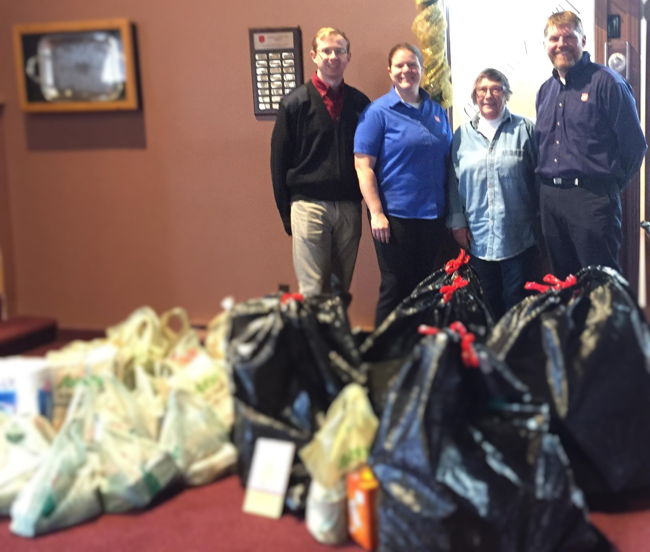Three Salvationists stand with Michelle and her donations for her adopted family