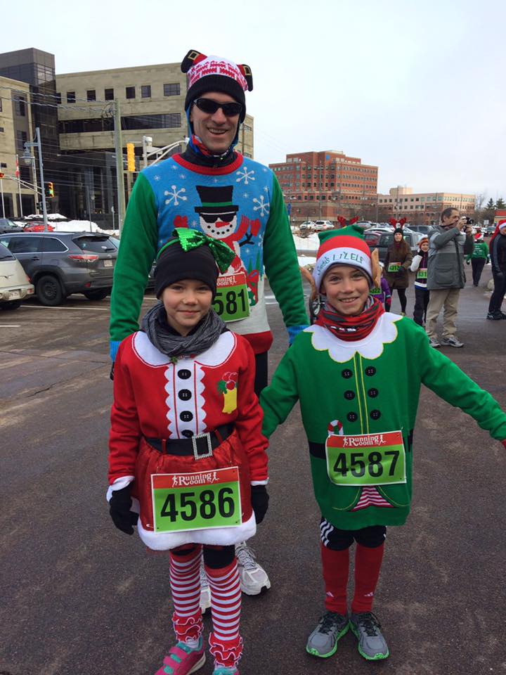 Three runners stand at the start line of the santa shuffle