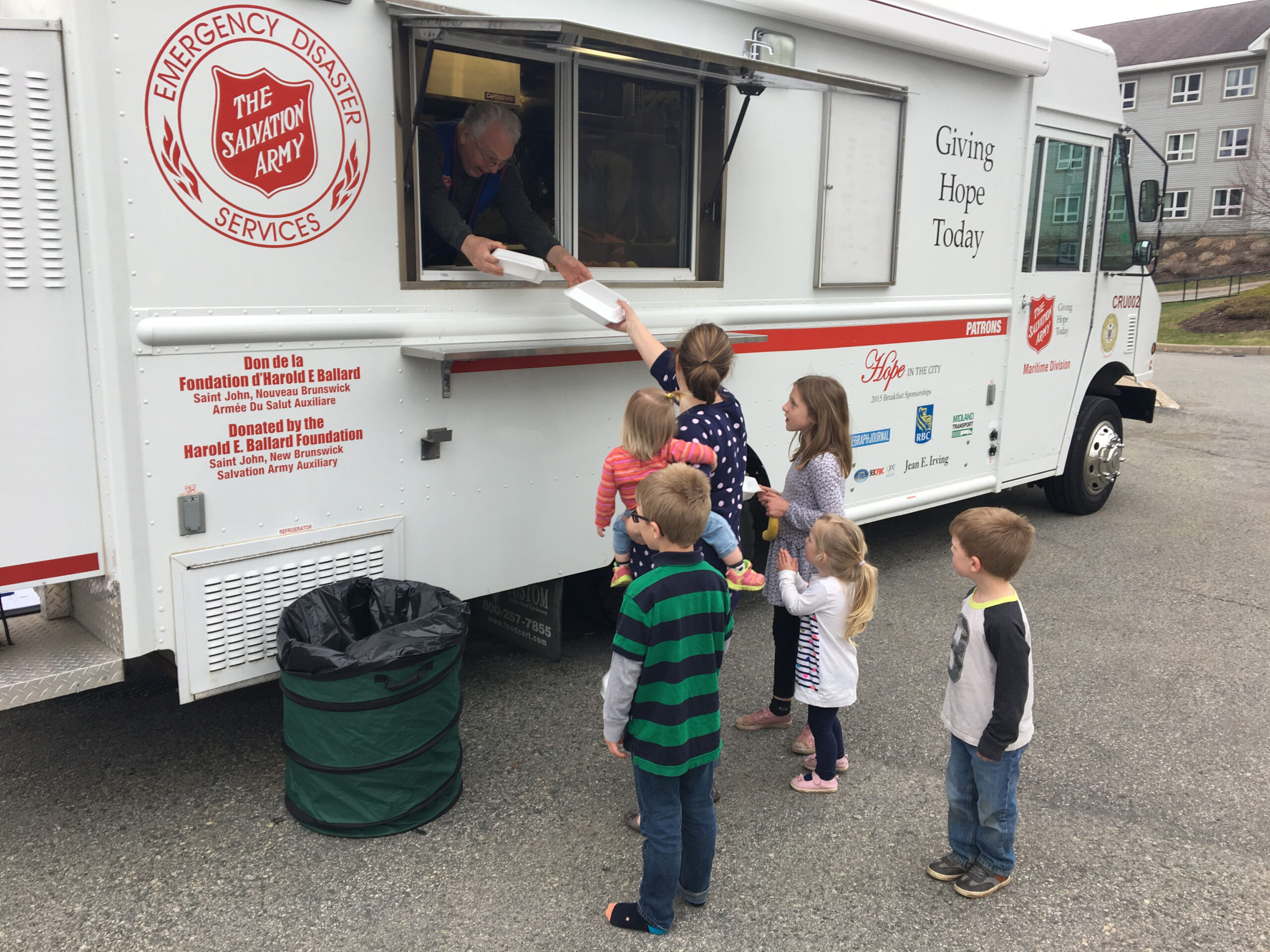 Mother and her children receive meals from The Salvation Army truck