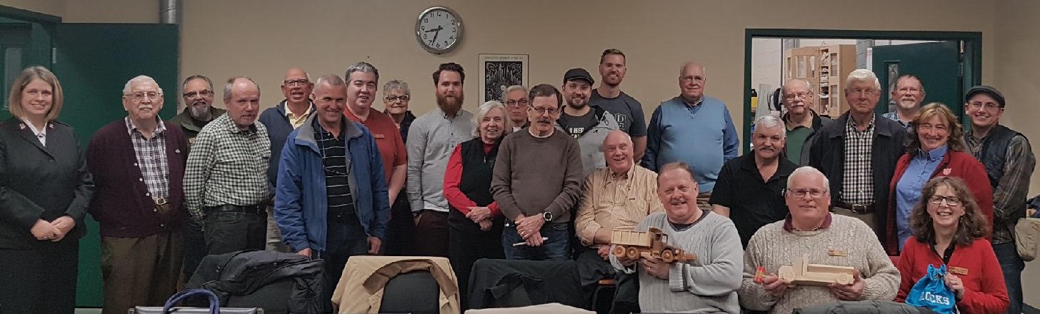 A group of individuals display the wooden toys they have created