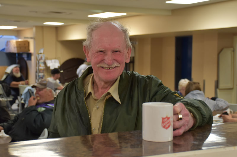 Man smiles and accepts coffee