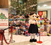 Sally Ann Mascott stands at kettle at toy mountain location with heaps of toys in background