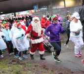 Participants , with Santa, in festive gear run in wet weather