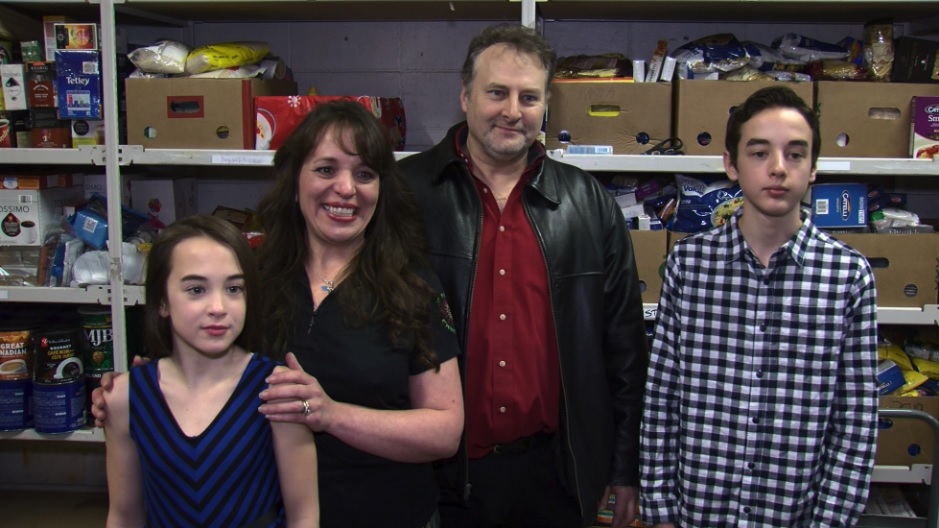 Local business man, Herb Millar, stands with wife and son and daughter at Salvation Army food bank