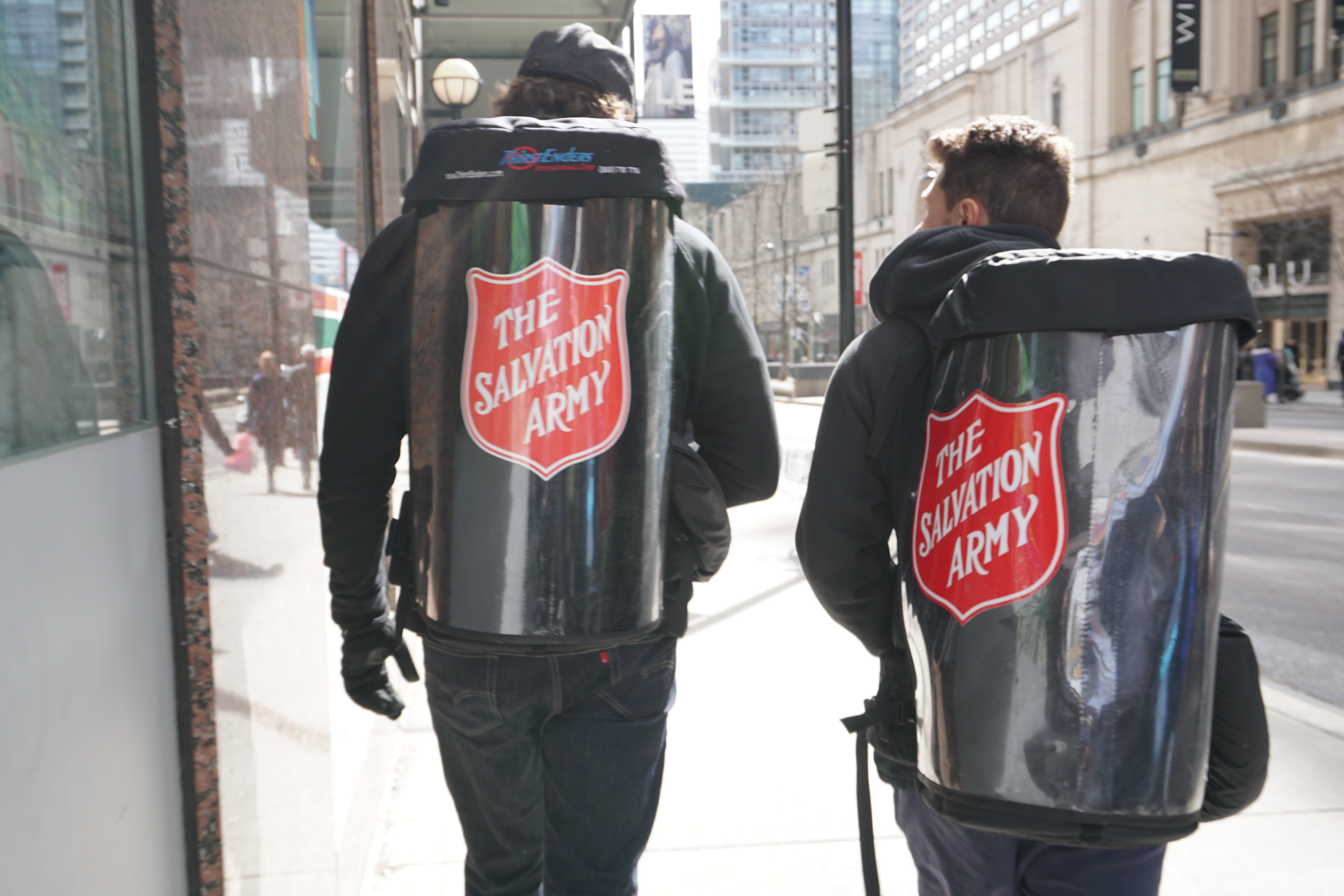 Two participants of Mission Toronto wearing Salvation Army cambro backpacks