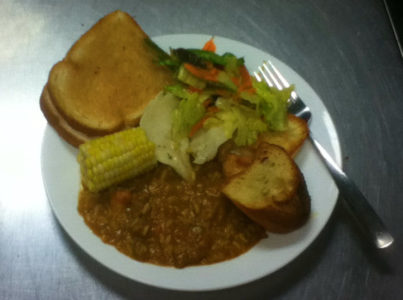 Photo of toast, beans, salad, and corn on a plate.