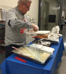 A volunteer serving a hot meal at Alpha 