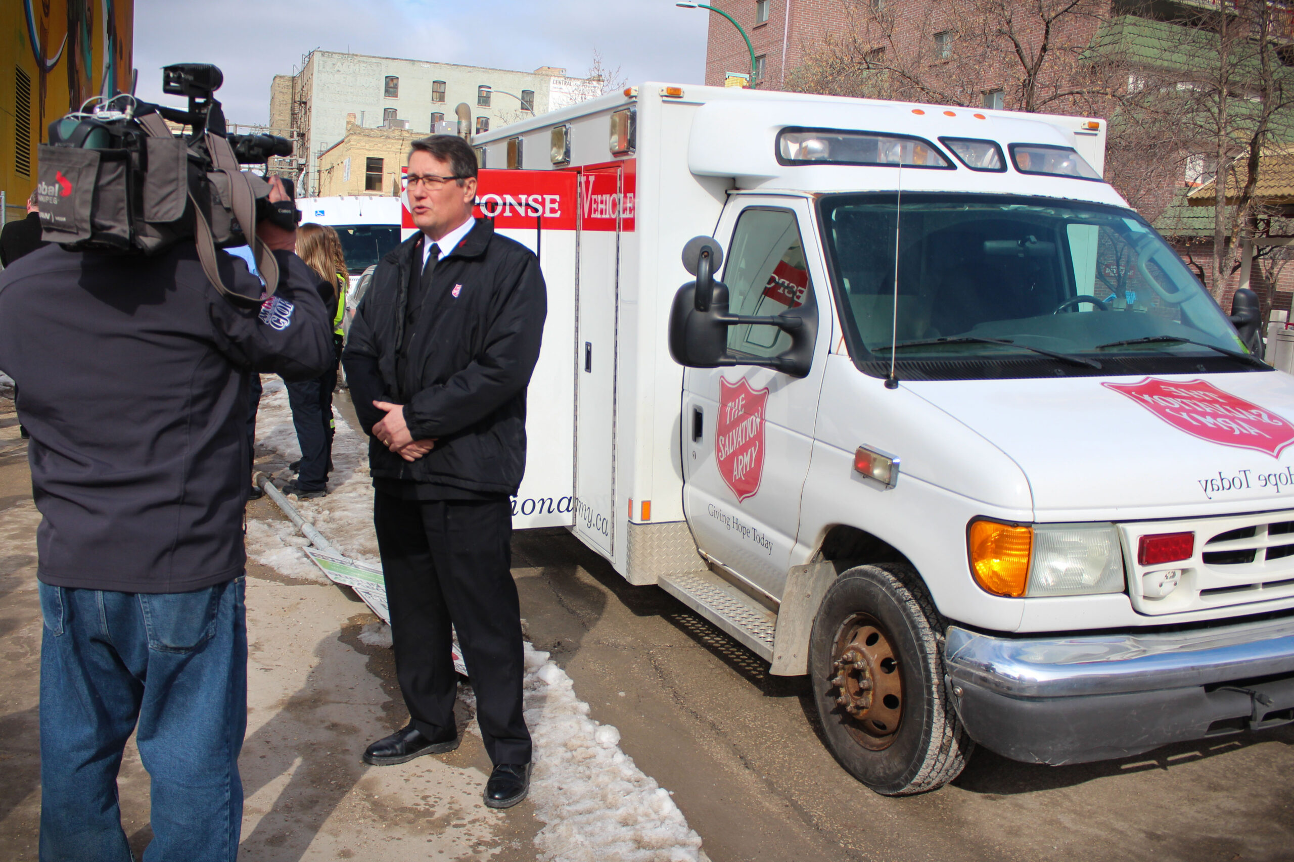 Major Kerr speaks with reporter in frot of vehicle