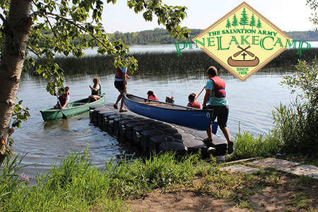 family putting canoe on lake