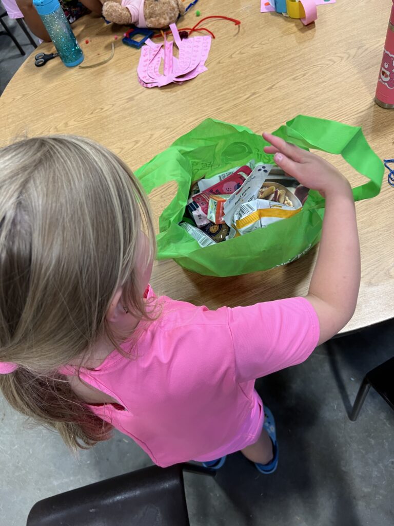 Girl looking into a bag packed with snacks