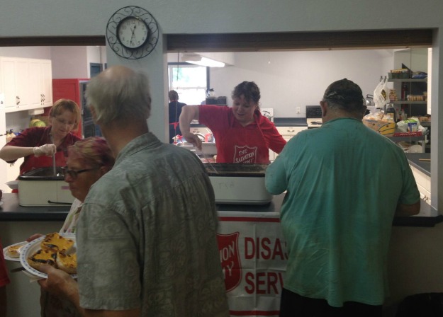 emergency disaster services workers serve food to evacuees and first responders