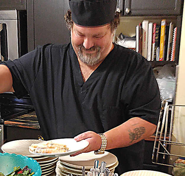 Aubrey Francis prepares meal for guests at Manna cafe