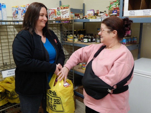 Food bank worker in Oshawa gives client bag of food