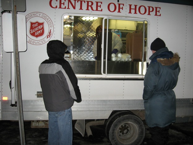 2 gentleman wait outside SA EDS vehicle for warm drink in cold weather