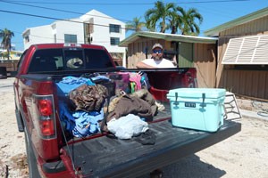 John unpacks personal items from truck, post Irma