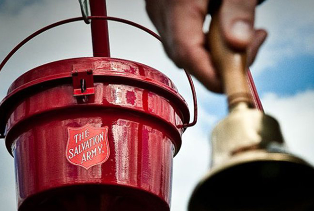 An image of a Salvation Army Kettle and a man rigging a bell