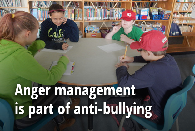 students gather around table to participate in anger management program