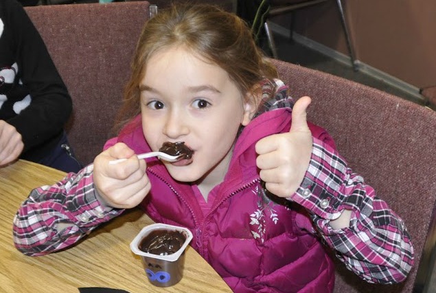 Young female participant enjoys snacks at March break camp