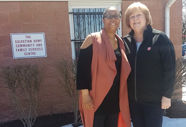 Michelle stands with Salvation Army worker, Ann, in front of Salvation Army church