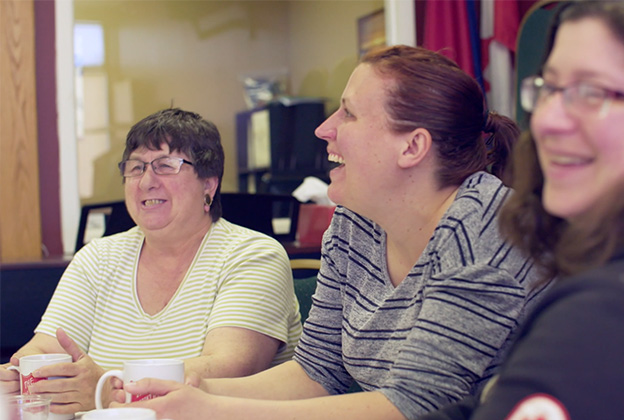 Photo of three mothers that attend The Salvation Army's "Moms and Tots" program. They are all sitting at a table laughing