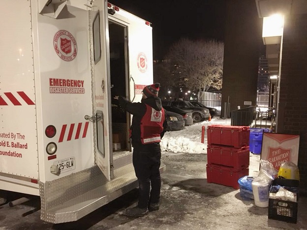 Salvation Army worker retrieves supplies from mobile feeding unit