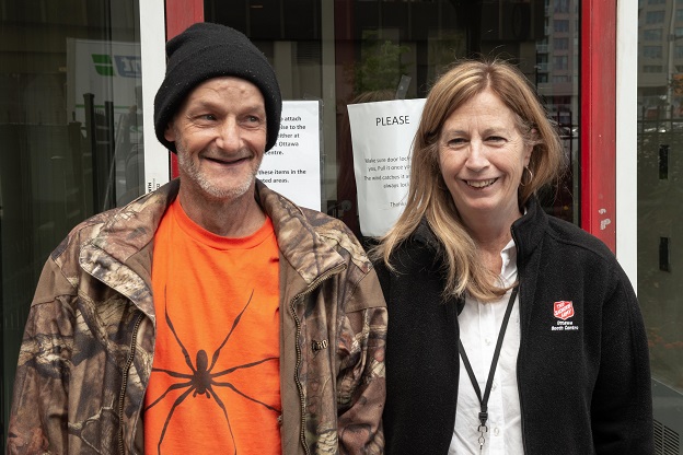 Lawrence stand with Salvation Army worker in front of Ottawa Booth Centre