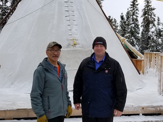 Inuk (left) and Jason (right) stand in front of tent in cold weather