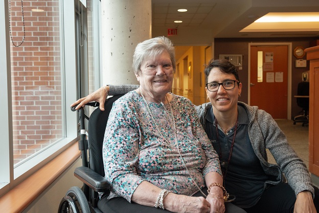 senior in wheelchair alongside long-term care staff member