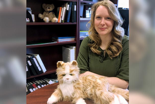Behavour management specialist, Nicole Butt, sits with robotics cat