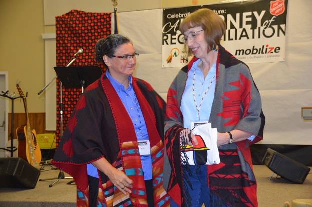 Major Shari Russell (left) and Commissioner Susan McMillan (right) learn more about the cultural diversity of the First Nations, Inuit, and Métis peoples.