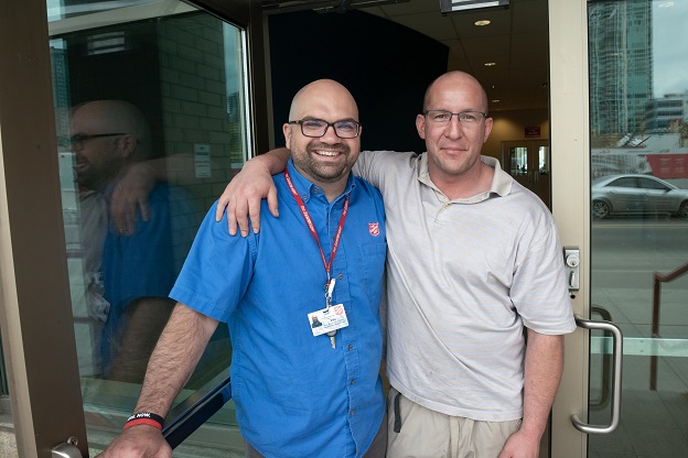 Greg (right) stands with Salvation Army worker in front of Calgary's Centre of Hope