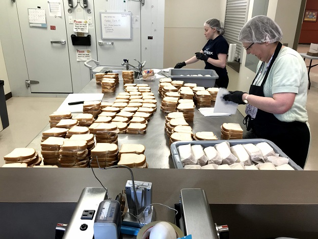 Volunteers make sandwiches for hungry children