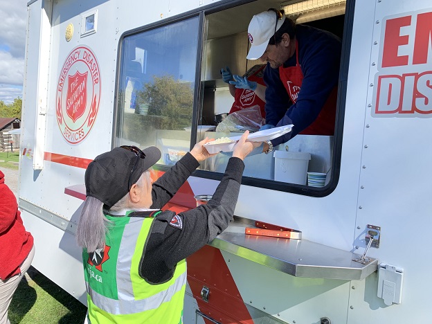 Salvation Army worker feeds first responder from EDS mobile unit