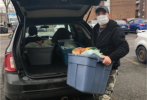 Volunteer delivers food hampers