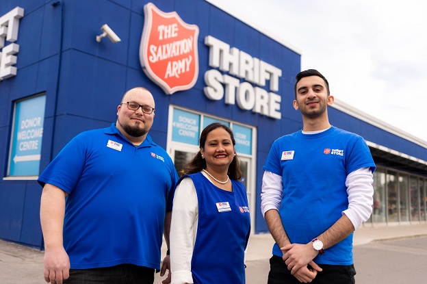 Thrift store employees stand in front of store