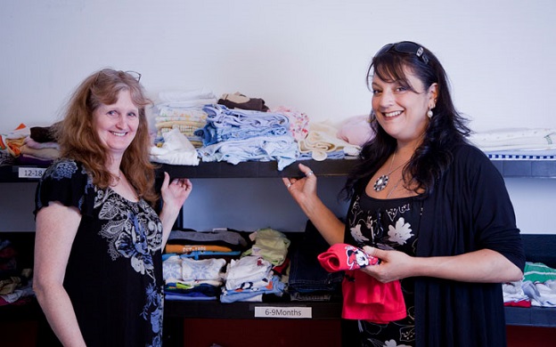 Salvation Army workers stand with items from Sonia's cradle program