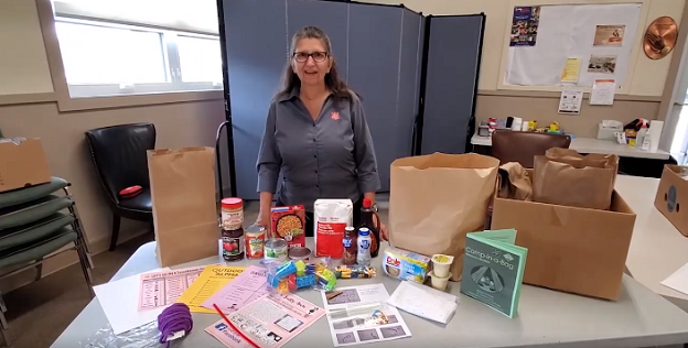 Major Karen Hoeft stands with camp in a bag articles