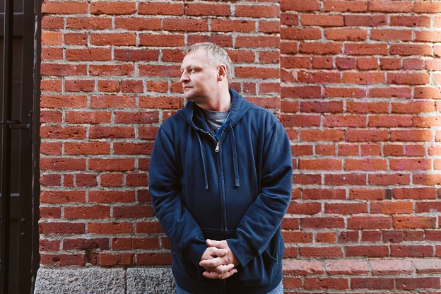 Eric stands in front of brick wall