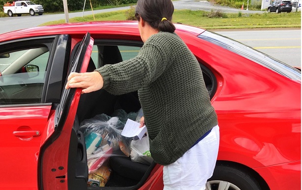 Jodi loads her car up with groceries to deliver to people who can't get to a food bank
