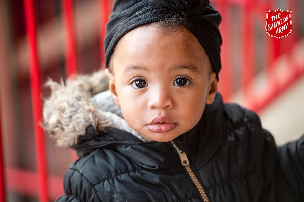 Little boy in winter coat stares into camera