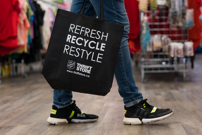 youth carrying black bag that says refresh, recycle, restyle