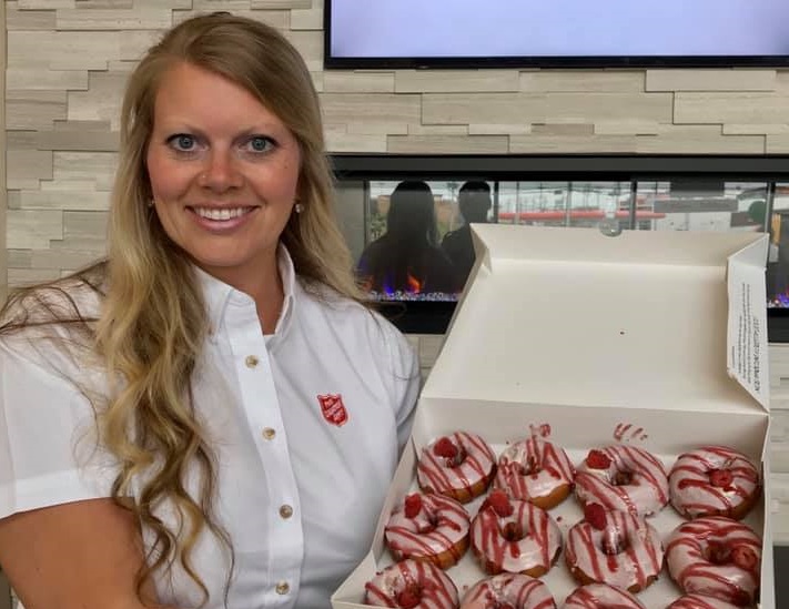 Salvation Army worker holds box of doughnuts for frontline workers