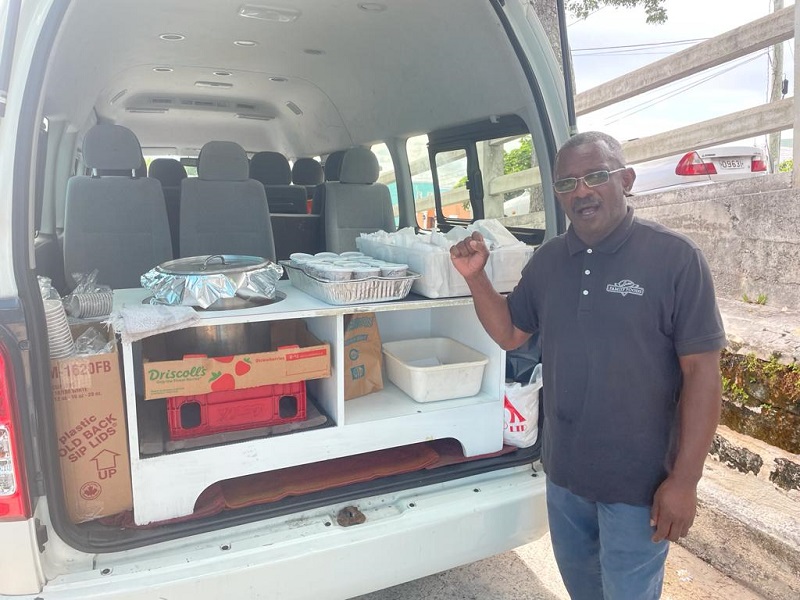 Maxwell Assing, street outreach worker, loads hot meals in the back of his van