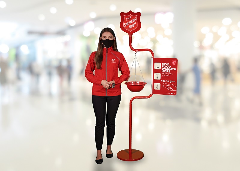 Kettle worker stands with red kettle and tap to donate tiles
