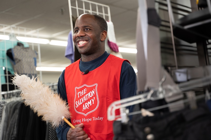 volunteer with duster at thrift store
